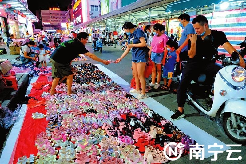在淡村商贸城,市民正给自家宝贝挑一双漂亮鞋子。