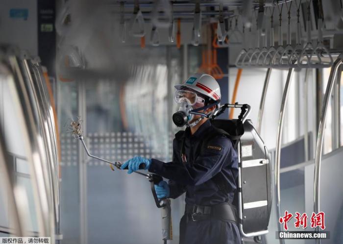 当地时间7月9日,日本东京,一名戴着防护面具和护目镜的东京地铁员工对车厢进行消毒。