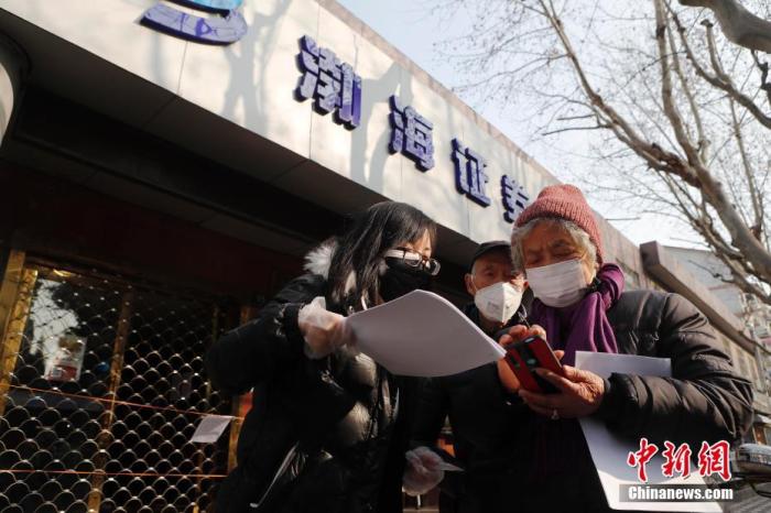 资料图：证券公司工作人员指导股民网上交易流程。中新社记者 殷立勤 摄