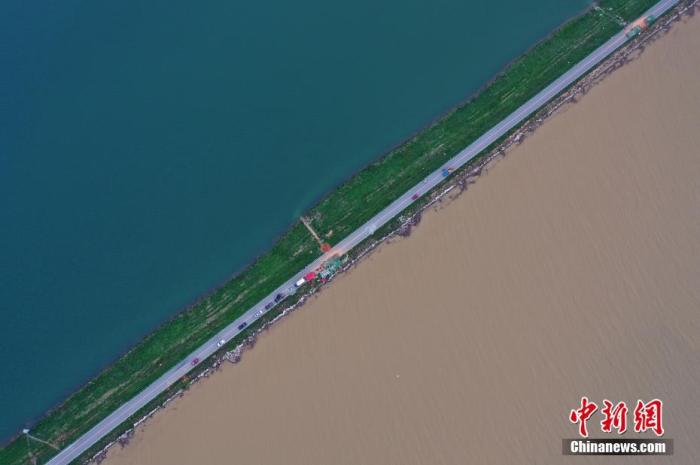 7月12日下午,航拍位于鄱阳湖东岸的江西鄱阳县珠湖联圩,一侧为清澈的鄱阳湖内湖珠湖,一侧为因暴雨变浑浊的鄱阳湖外湖,呈现一堤之隔泾渭分明的景观。 中新社记者 刘占昆 摄
