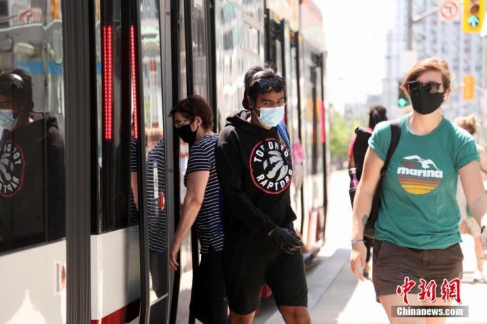 当地时间7月3日，佩戴口罩的民众在加拿大多伦多搭乘电车。多伦多公共交通局自7月初起施行防疫新规，强制要求所有公共交通工具乘客佩戴口罩。 中新社记者 余瑞冬 摄