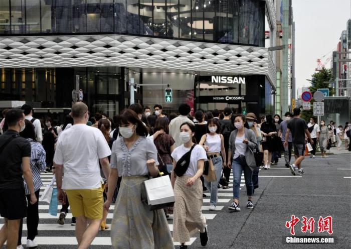 当地时间6月6日,日本东京都发布新冠肺炎疫情“东京警报”后的首个周末,当地选择出门逛街的民众数量并没有大幅减少。图为当地民众佩戴口罩走过东京街头。 中新社记者 吕少威 摄
