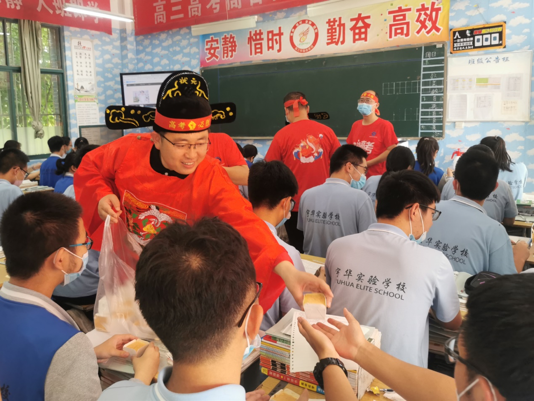金广磊和同事扮成“状元、榜眼、探花”，到高三各班送粽子和蛋糕。受访者供图
