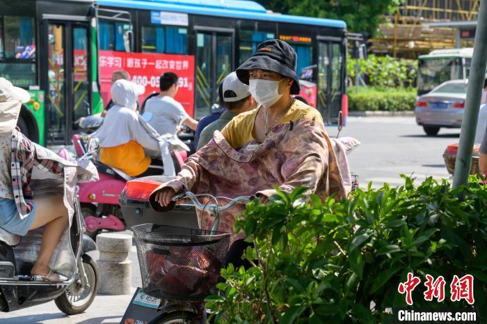 资料图:7月13日福州民众出行“全副武装”抵御烈日。 李南轩 摄