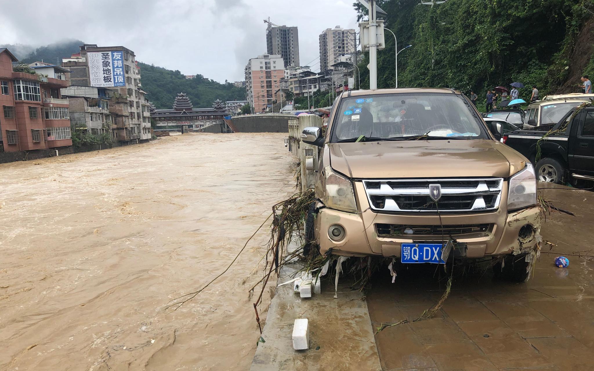 7月26日，建始县广润河发生洪水，几十台车辆被淹，岸边栏杆损毁，不少车辆被冲入河中。新京报记者 向凯 摄