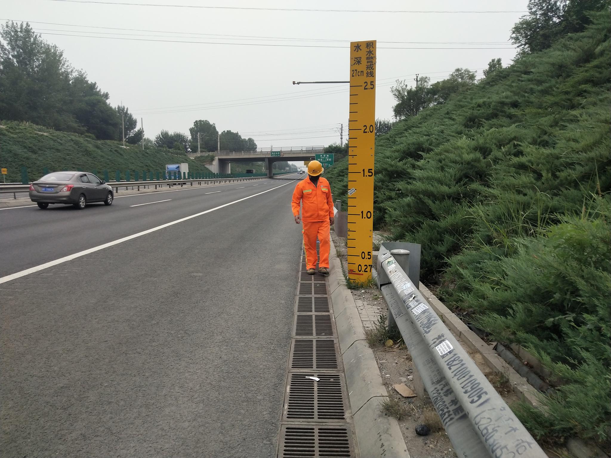 养护职员正在查抄高速公路旁的雨水箅子。首发养护公司供图