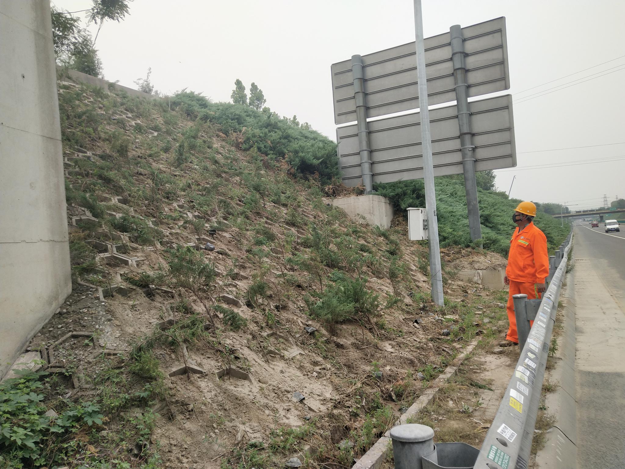 事情职员在查抄高速公路锥坡,针对山体易滑坡路段,将放置铲车、发掘机备勤。首发养护公司供图