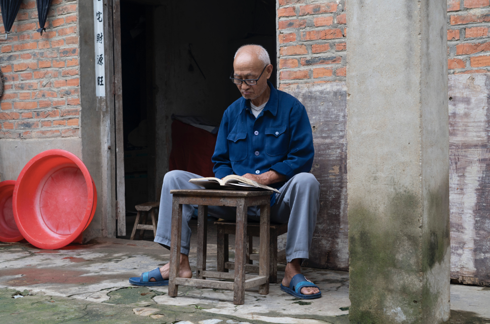 淮堤上,在一栋长满青苔的老房子里,72岁的徐如贺正坐在门口板凳上看书,读的是《资治通鉴》。墙外十几米远,就是上涨的淮河水。新京报记者解蕾摄