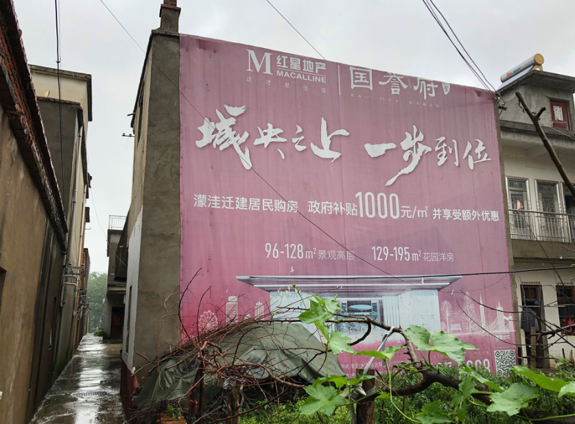 老观乡村里,挂着迁建居民购房广告。新京报记者解蕾摄