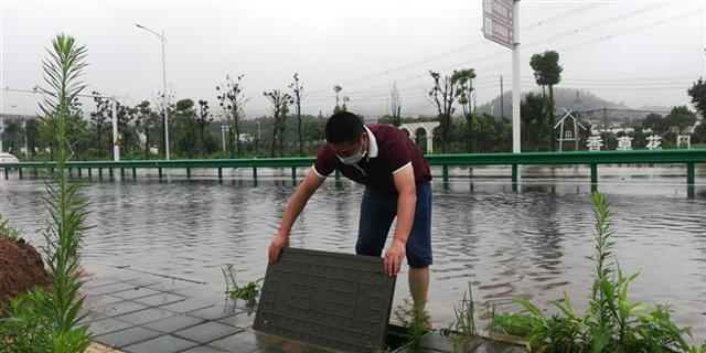 大雨中,公交线长脱掉鞋袜积水中清理污物