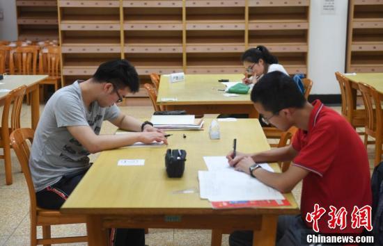 资料图：6月18日，浙江省杭州第二中学三名高三学生在图书馆自习。 中新社记者 王刚 摄