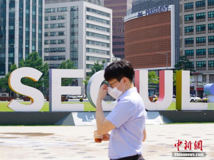 6月23日,一位韩国首尔市民经过首尔广场。近来,包括韩国首尔、仁川、京畿道在内的首都圈确诊病例持续增加。 中新社记者 曾鼐 摄