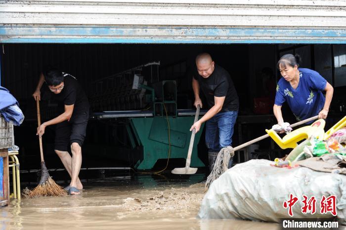 图为洪水退去后的安徽省黄山市歙县经济开发区,受灾企业员工正在清理淤泥。 张娅子 摄