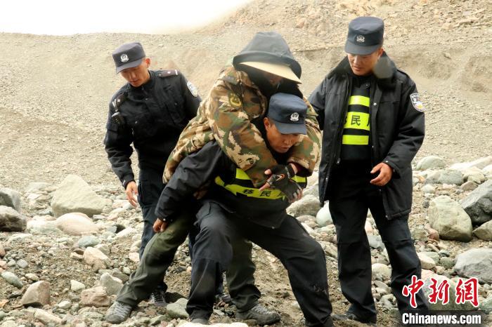 图为西藏阿里边境管理支队塔尔钦边境派出所民警背着受伤游客下山。　杨晓川 摄