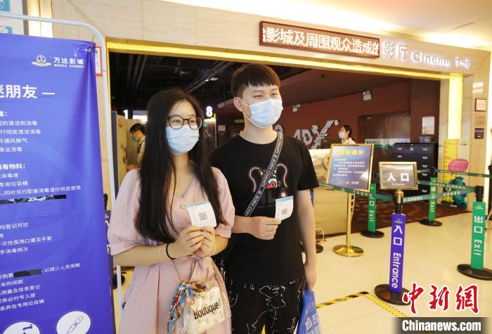 两位市民展示刚刚买到的电影票。 黄余洋 摄