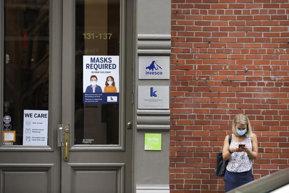 7月30日,在美国纽约苏豪商业区,一栋建筑的门上贴有防疫提示.