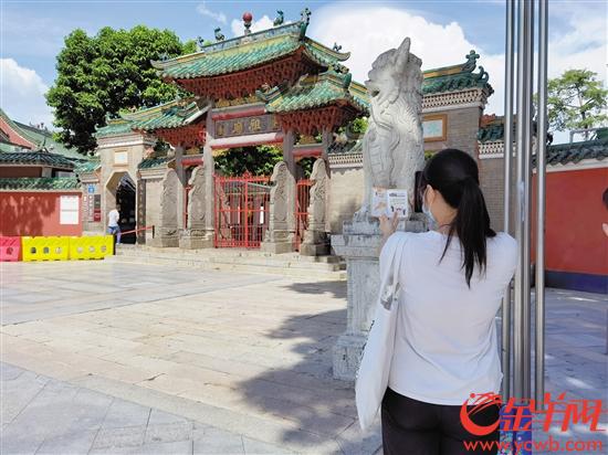 　一名游客在佛山祖庙博物馆门前拍照留念