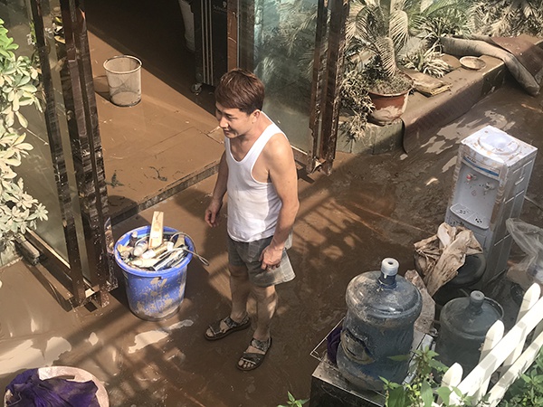 一家理发店被洪水淹没后,留下满地淤泥。