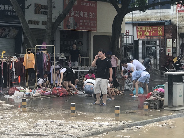 洪涝致沿街商铺受损,经营者清理淤泥以及被污水浸染的物品。本文图片 澎湃新闻记者 何利权 摄