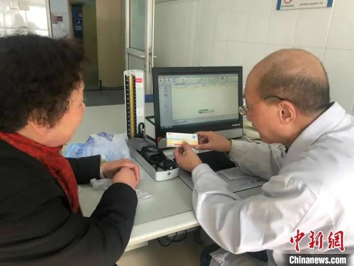 资料图:一位医生在给患者介绍药品。 王怡苹 摄