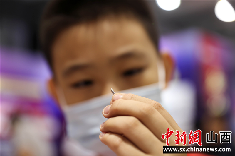 观展小学生手握太钢“笔尖钢” 张云 摄