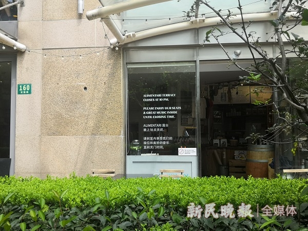 图说：玻璃墙上写明露台10点关闭，但居民反映，店家不自觉  夏韵 摄