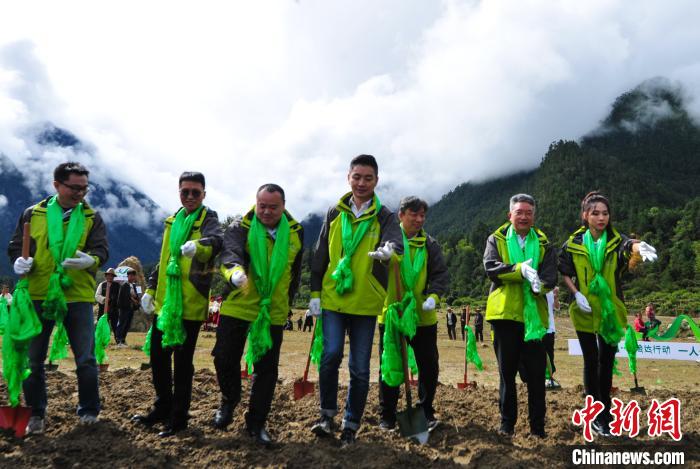 图为活动参与者在西藏林芝米林县德吉新村播撒草籽。　张伟 摄
