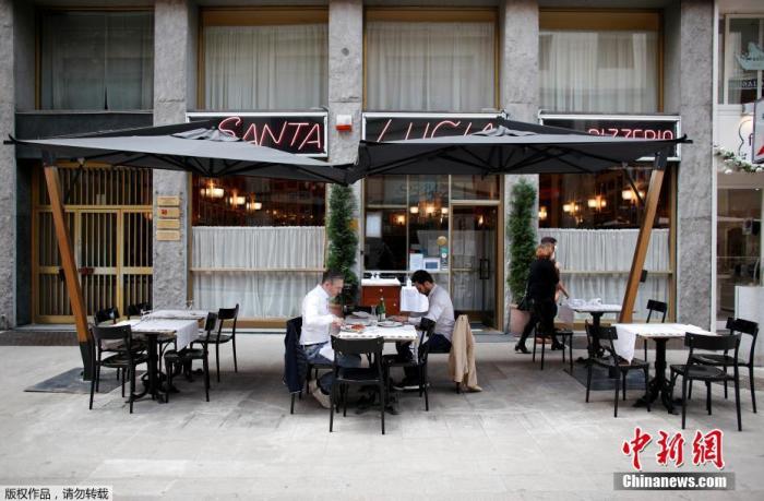 资料图:当地时间5月18日,意大利米兰,顾客坐在餐厅的露台上就餐