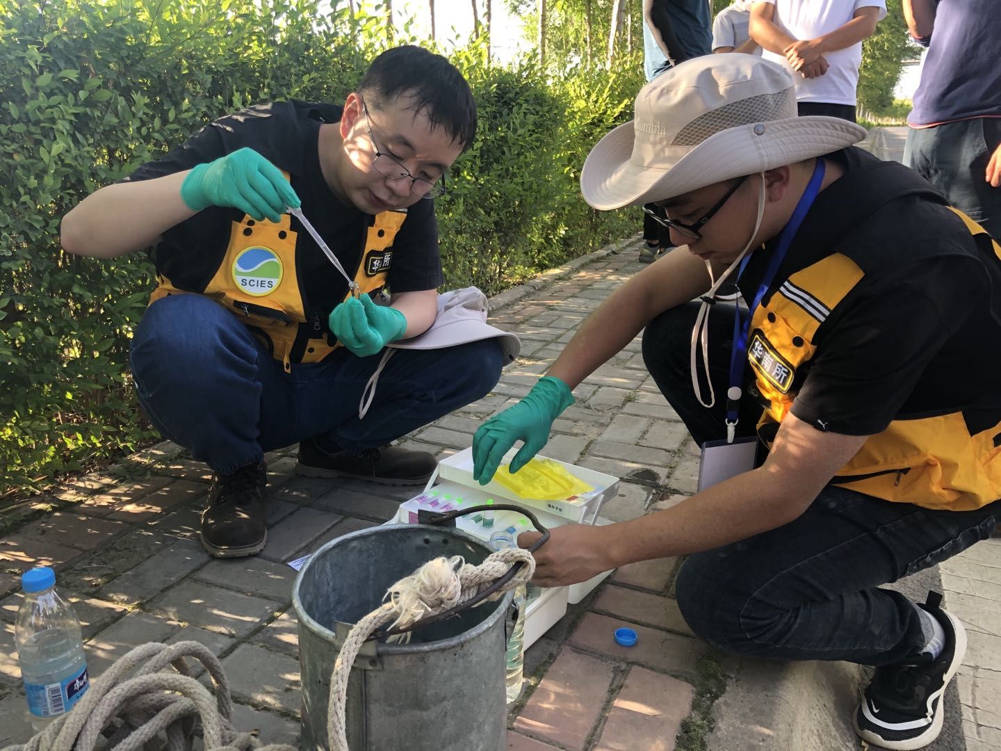 8月25日,胡立才(左一)和同事在湟水河边取水快速检测。摄影/新京报记者 邓琦