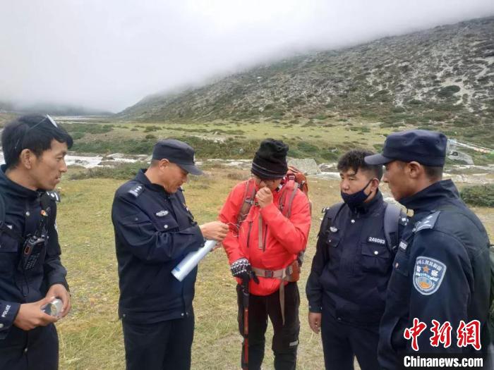 图为救济职员为该名走失旅客(中)提供氧气瓶。聂拉木县公安局 供图