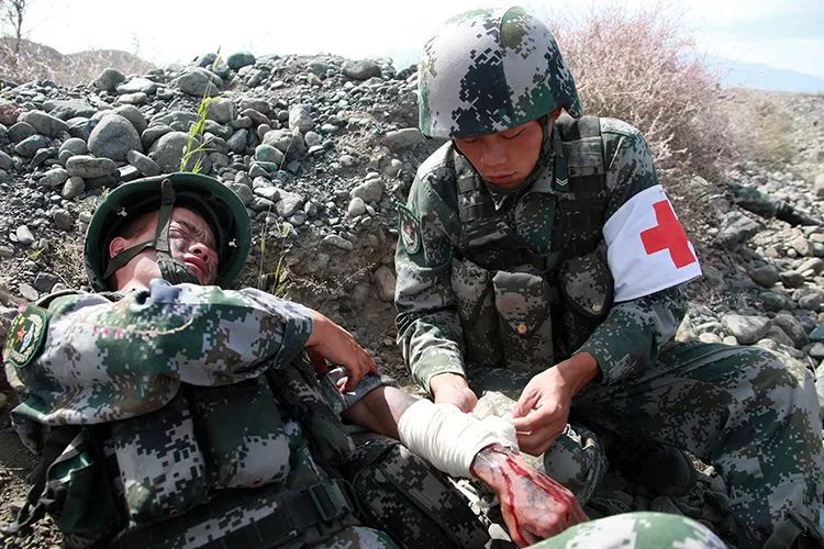 战士左臂"受伤",卫生员紧急进行包扎处理.