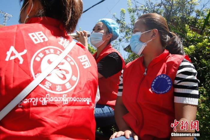 9月19日,24岁的缅甸华侨曾莉带着两名缅籍华人志愿者来到云南省瑞丽市芒喊村,轮流用汉语和缅甸语进行疫情防控宣传。图为曾莉(中)和两名缅籍华人志愿者在村子中进行疫情防控宣传。 中新社记者 蒋启明 摄
