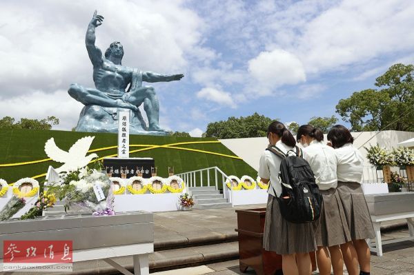 资料图片:8月9日,人们在日本长崎和平公园内的和平祈念像前悼念.