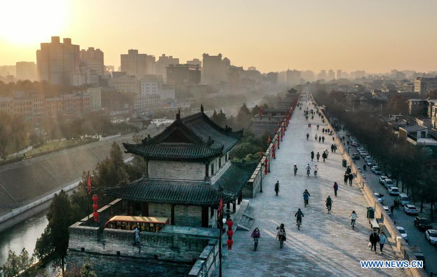 Aerial photo taken on Jan. 1, 2021 shows people visiting the ancient city wall at sunset in Xi'an, northwest China's Shaanxi Province. (Xinhua/Tao Ming)