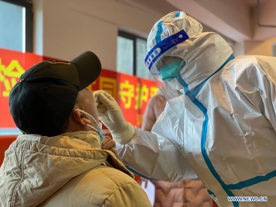 A medical worker collects a swab sample from a resident at a coronavirus testing site in Hunnan District of Shenyang, northeast China's Liaoning Province, Jan. 1, 2021. Shenyang is conducting nucleic acid tests for all residents in nine districts starting Thursday, local authorities said. The extensive testing drive covering most urban areas is aimed at screening coronavirus infections. (Xinhua/Li Ang)