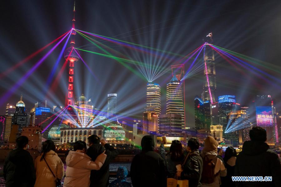People enjoy the light show at the Bund in east China's Shanghai, Jan. 2, 2021. (Xinhua/Wang Xiang)