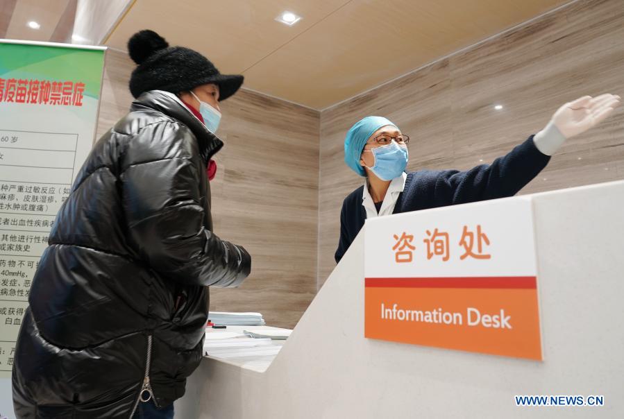 A staff member guides a woman who is here to be inoculated with the COVID-19 vaccine at a healthcare center in Honglian Community in Xicheng District of Beijing, capital of China, Jan. 3, 2021. Beijing has started administering COVID-19 vaccines among specific groups of people with higher infection risks. Nine groups of people aged 18 to 59 will receive the vaccine before the Spring Festival of 2021, which falls on Feb. 12. These include frontline customs inspectors of imported cold-chain goods and personnel working in the overseas and domestic transportation sector. (Xinhua/Zhang Chenlin)