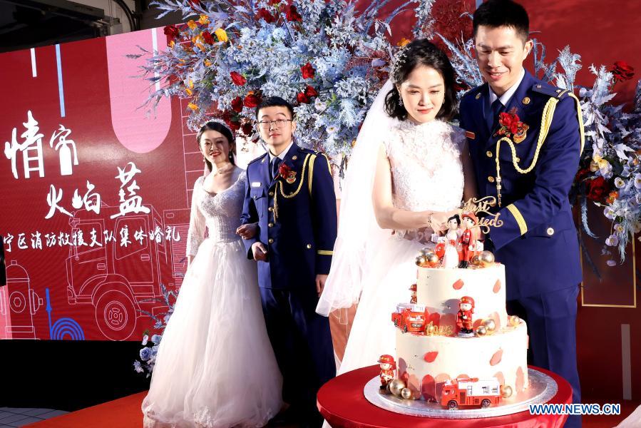 Firefighters and their wives attend a group wedding ceremony in east China's Shanghai, Jan. 4, 2021. A fire brigade in Shanghai's Changning District on Monday held a group wedding for four firefighter couples, whose weddings were postponed as a result of their service in the fight against COVID-19. (Xinhua/Chen Fei)