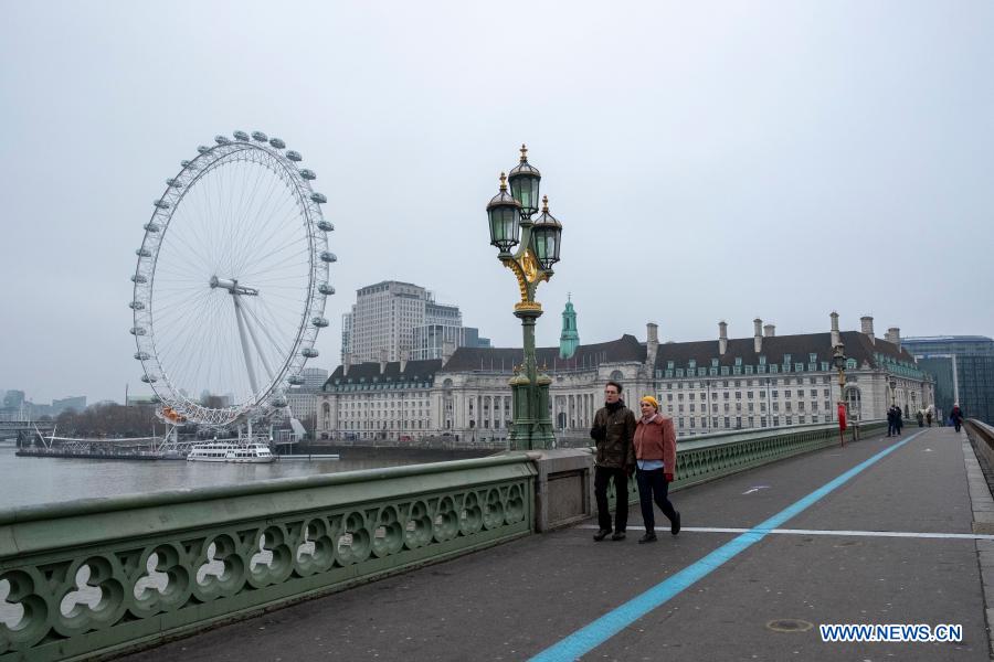 People walk along the Westminster Bridge in London, Britain, on Jan. 1, 2021. (Photo by Ray Tang/Xinhua)