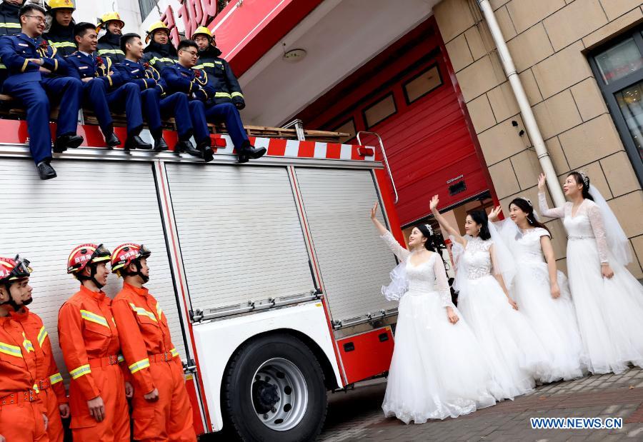 Firefighters and their wives pose for wedding photos during a group wedding ceremony in east China's Shanghai, Jan. 4, 2021. A fire brigade in Shanghai's Changning District on Monday held a group wedding for four firefighter couples, whose weddings were postponed as a result of their service in the fight against COVID-19. (Xinhua/Chen Fei)