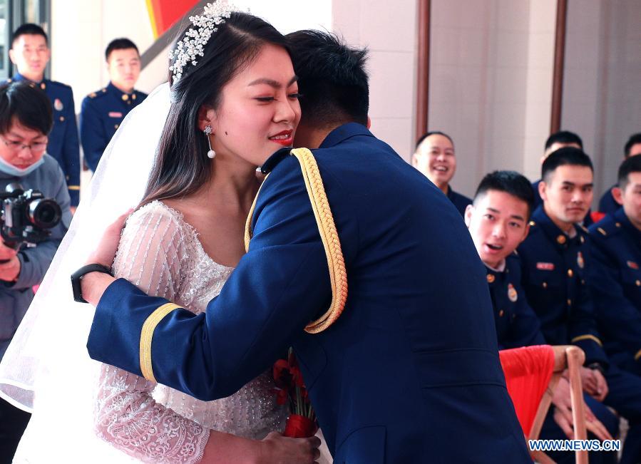 Firefighter Yuan Yang hugs his bride Xu Lu during a group wedding ceremony in east China's Shanghai, Jan. 4, 2021. A fire brigade in Shanghai's Changning District on Monday held a group wedding for four firefighter couples, whose weddings were postponed as a result of their service in the fight against COVID-19. (Xinhua/Chen Fei)