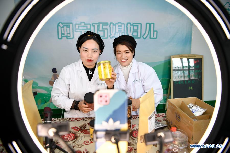 Hai Yan (L) and Ma Yan introduce products via livestreaming at Minning Hemei e-commerce poverty alleviation workshop in Yuanlong Village in Minning Township in Yinchuan, northwest China's Ningxia Hui Autonomous Region, Nov. 11, 2020. Xihaigu, one of China's most impoverished areas located in Ningxia, saw its last impoverished county removed from the national poverty list on Nov. 16, 2020. Over 60,000 farmers in Xihaigu have been relocated to Minning Township, which has converted from a town in Gobi desert to a modernized ecological relocation demonstration town over the past two decades via a series of cooperation between Ningxia and southeast China's Fujian Province. The victory is regarded as another landmark in China's campaign to eradicate absolute poverty, during which 