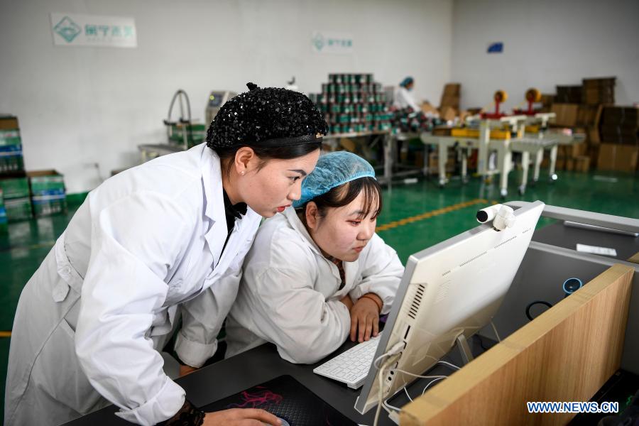 Hai Yan (L) and Ma Danli work at a Minning Hemei e-commerce poverty alleviation workshop in Yuanlong Village in Minning Township in Yinchuan, northwest China's Ningxia Hui Autonomous Region, Nov. 11, 2020. Xihaigu, one of China's most impoverished areas located in Ningxia, saw its last impoverished county removed from the national poverty list on Nov. 16, 2020. Over 60,000 farmers in Xihaigu have been relocated to Minning Township, which has converted from a town in Gobi desert to a modernized ecological relocation demonstration town over the past two decades via a series of cooperation between Ningxia and southeast China's Fujian Province. The victory is regarded as another landmark in China's campaign to eradicate absolute poverty, during which 