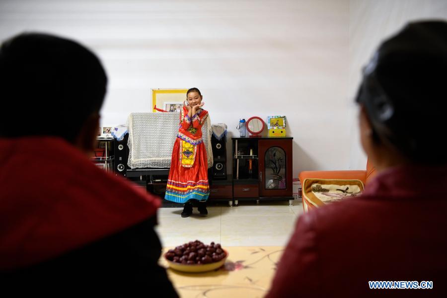 Bai Xiyan (R) watches her daughter dancing at home in Yuanlong Village in Minning Township in Yinchuan, northwest China's Ningxia Hui Autonomous Region, Nov. 10, 2020. Xihaigu, one of China's most impoverished areas located in Ningxia, saw its last impoverished county removed from the national poverty list on Nov. 16, 2020. Over 60,000 farmers in Xihaigu have been relocated to Minning Township, which has converted from a town in Gobi desert to a modernized ecological relocation demonstration town over the past two decades via a series of cooperation between Ningxia and southeast China's Fujian Province. The victory is regarded as another landmark in China's campaign to eradicate absolute poverty, during which 