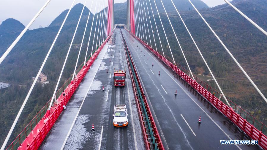 Aerial photo shows workers sprinkling salt to clear ice off the road on Yachi River Bridge in southwest China's Guizhou Province, Jan. 7, 2021. Workers sprinkled salt on roads to ensure traffic safety after snow and rain hit Guizhou Province on Thursday. (Xinhua/Tao Liang)