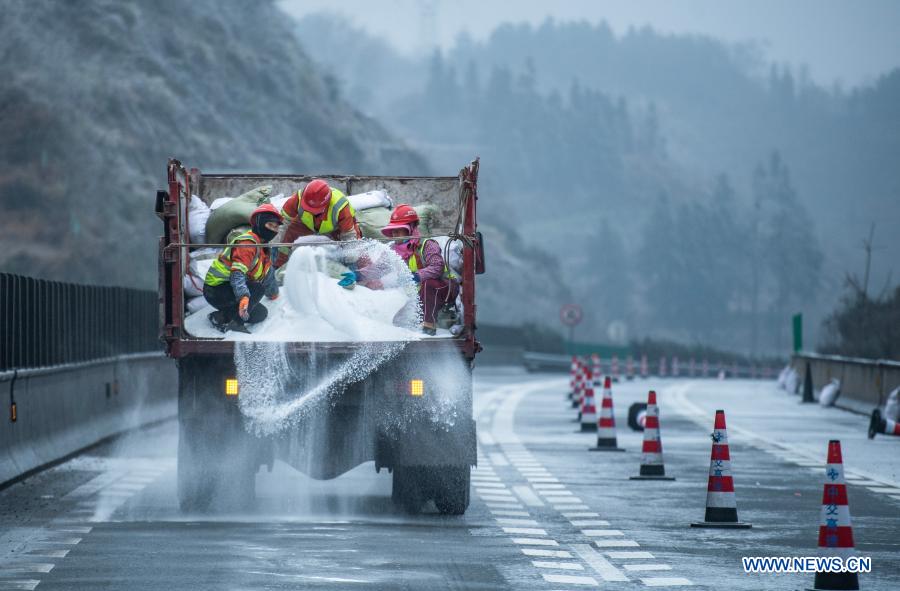 Workers sprinkle salt to clear ice off a road in southwest China's Guizhou Province, Jan. 7, 2021. Workers sprinkled salt on roads to ensure traffic safety after snow and rain hit Guizhou Province on Thursday. (Xinhua/Tao Liang)