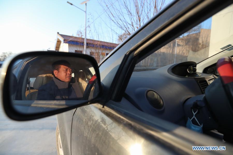 Ren Zhangtai drives to visit villagers in Yuanjiaping Village of Hanjiaji Town in Huining County, northwest China's Gansu Province, Jan. 5, 2021. Yuanjiaping Village, with 2,331 villagers of 538 households, was once an impoverished village with a poverty rate of 73.18 percent. Ren Zhangtai, 54, has been the secretary of Communist Party of China (CPC) branch of Yuanjiaping Village for 15 years. With Ren's consistent efforts and the support of poverty alleviation policies, the village has developed multiple industries led by vegetable cultivation. In 2018, the village shook off poverty. In 2020, Ren was awarded the provincial model worker title. (Xinhua/Ma Xiping)