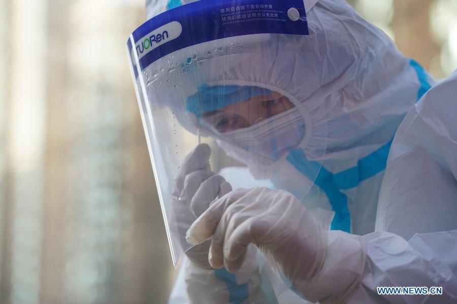 A medical worker adjusts her face shield at a coronavirus testing site in Qiaoxi District of Shijiazhuang, capital of north China's Hebei Province, Jan. 6, 2021. Shijiazhuang started to conduct citywide nucleic acid tests covering all citizens on Wednesday. (Xinhua/Mu Yu)