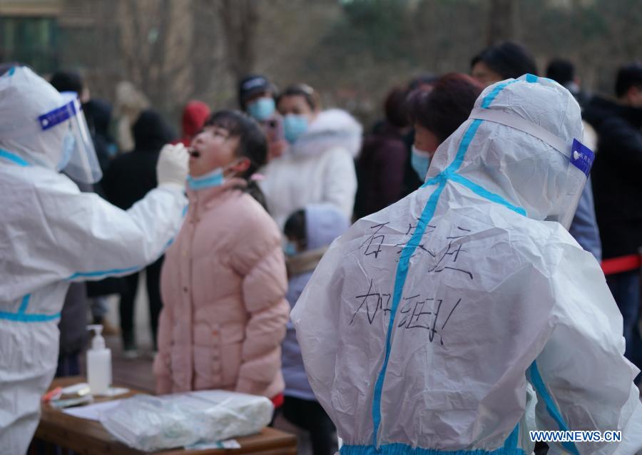 Medical workers collect swab samples from residents at a community in Qiaoxi District of Shijiazhuang, capital of north China's Hebei Province, Jan. 6, 2021. Shijiazhuang started to conduct citywide nucleic acid tests covering all citizens on Wednesday. (Xinhua/Mu Yu)