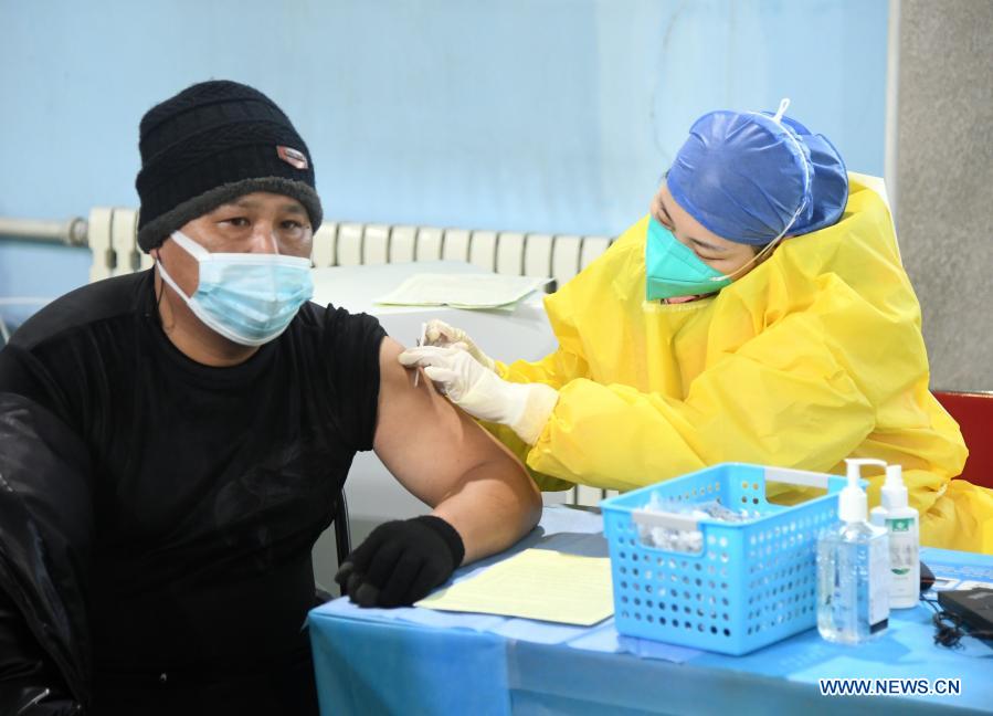 A medical worker administers a shot of the COVID-19 vaccine to a man at a temporary vaccination site in Haidian District of Beijing, capital of China, Jan. 6, 2021. (Xinhua/Ren Chao)